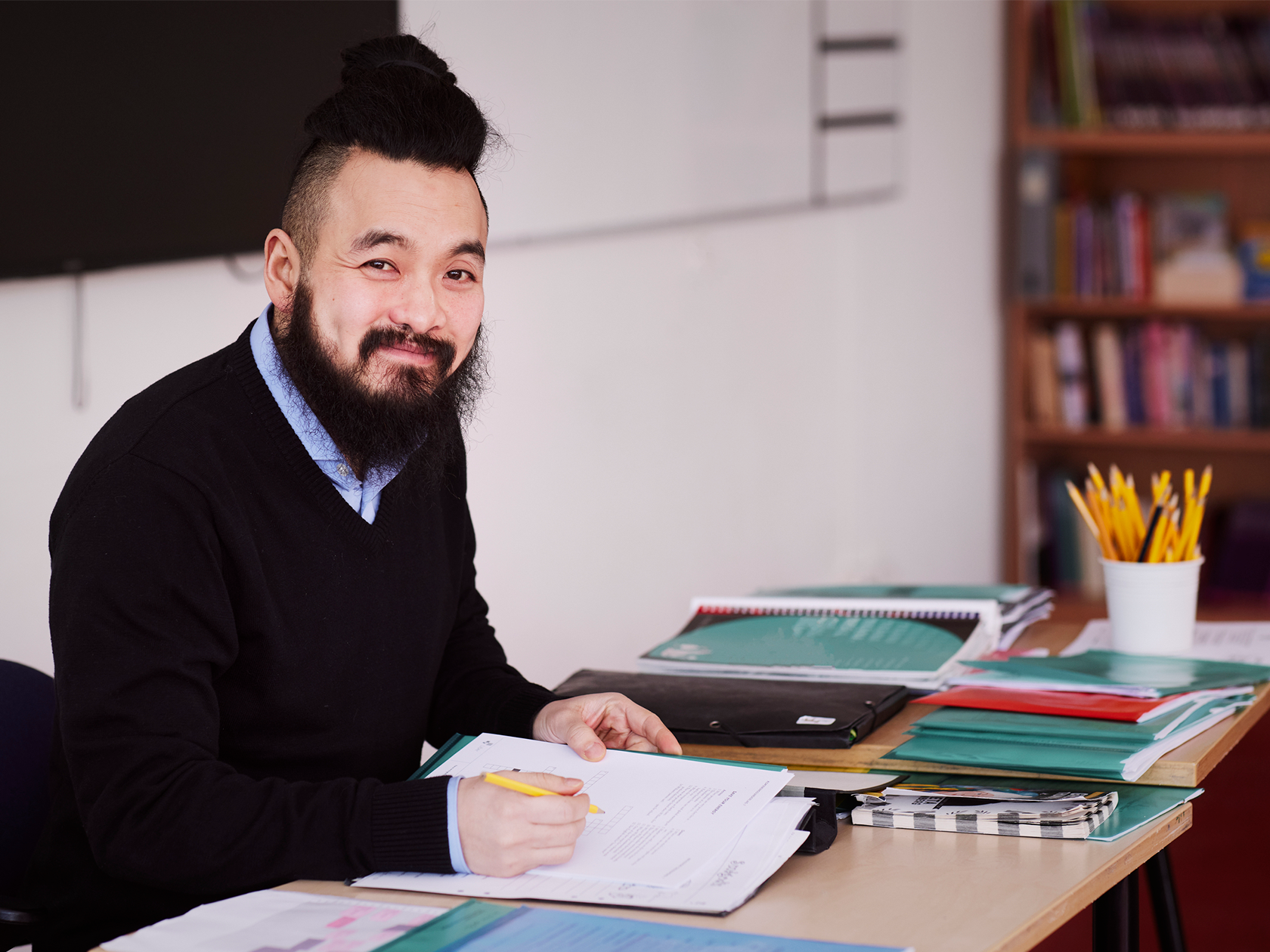 Lärare som ler och bedömer prov