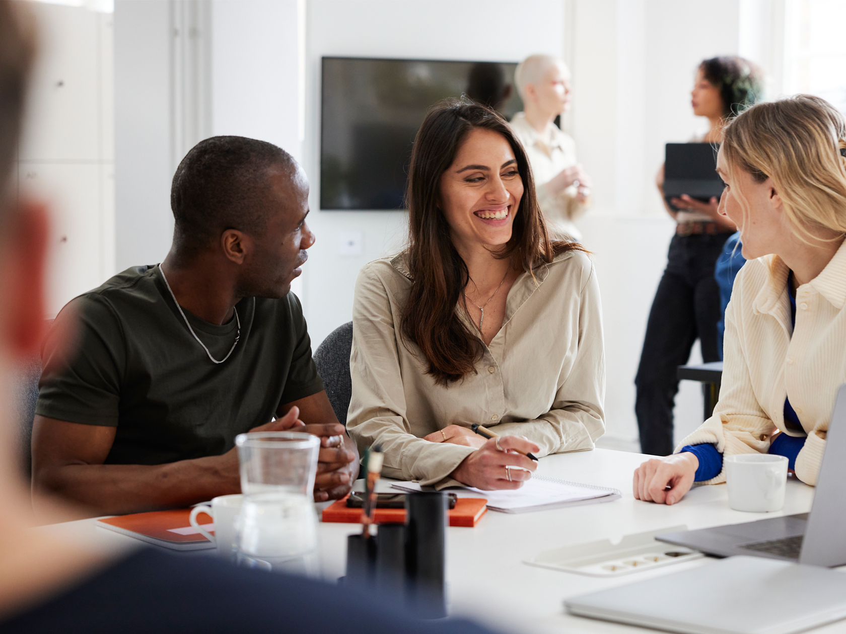 Tre personer samtalar i klassrummet