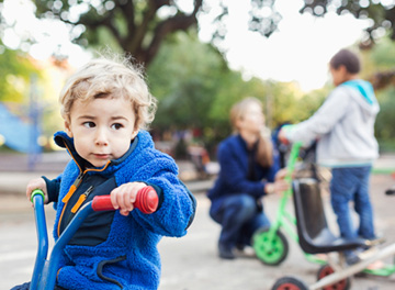 Förskolebarn som åker på trehjuling 