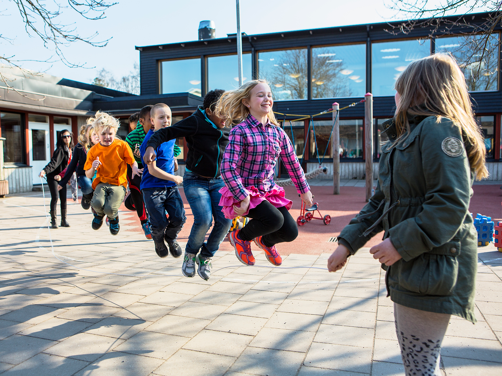 Barn som hoppar hopprep tillsammans