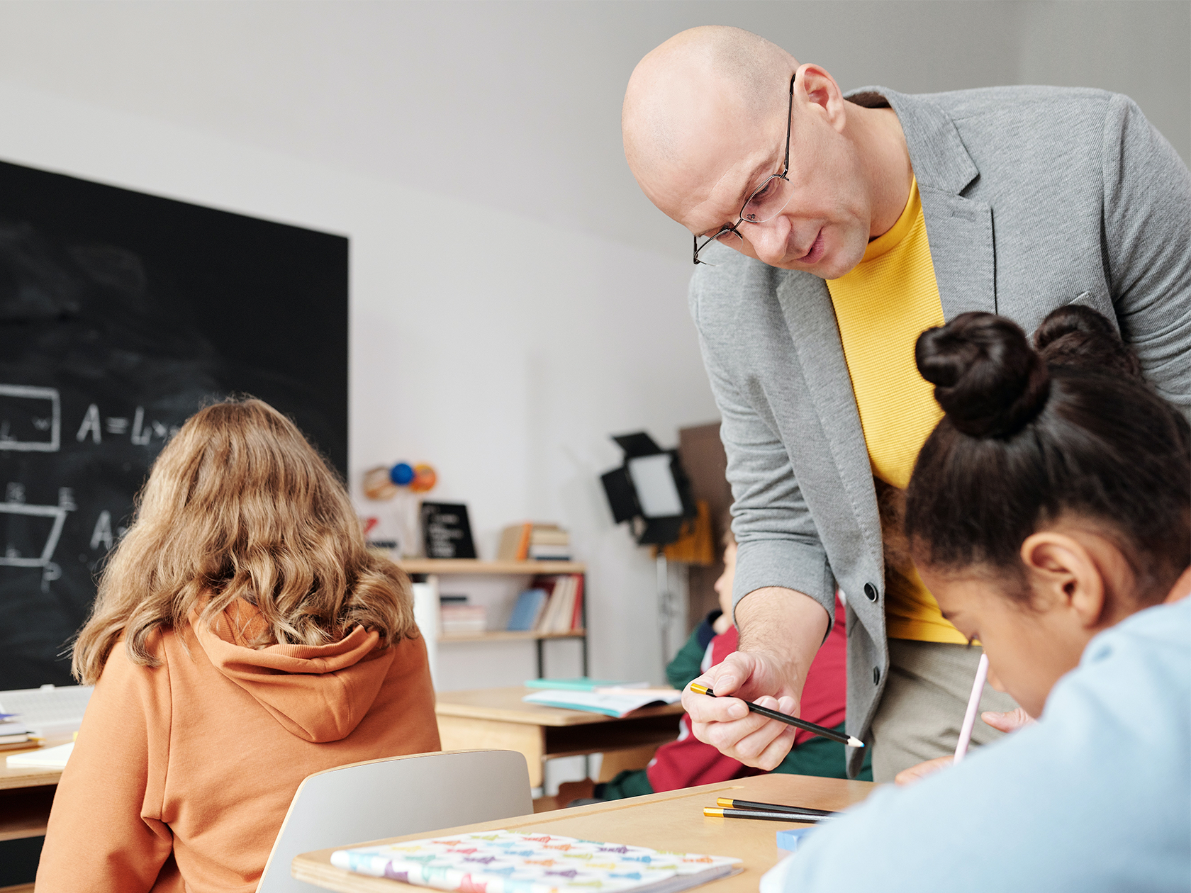 Lärare som hjälper elev med uppgift